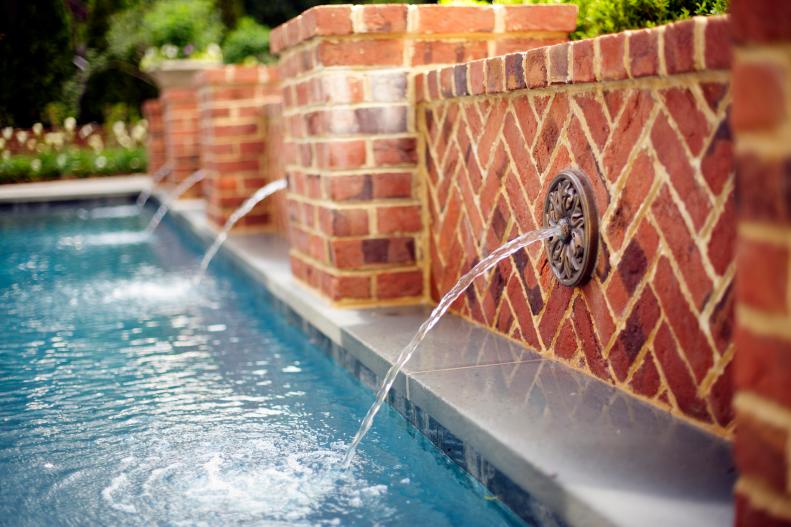 Combining recreation with a sense of tranquility, this swimming pool from Tuckahoe Creek Construction is fed by bronze medallion fountains mounted on a brick facade and set off by a bluestone patio.