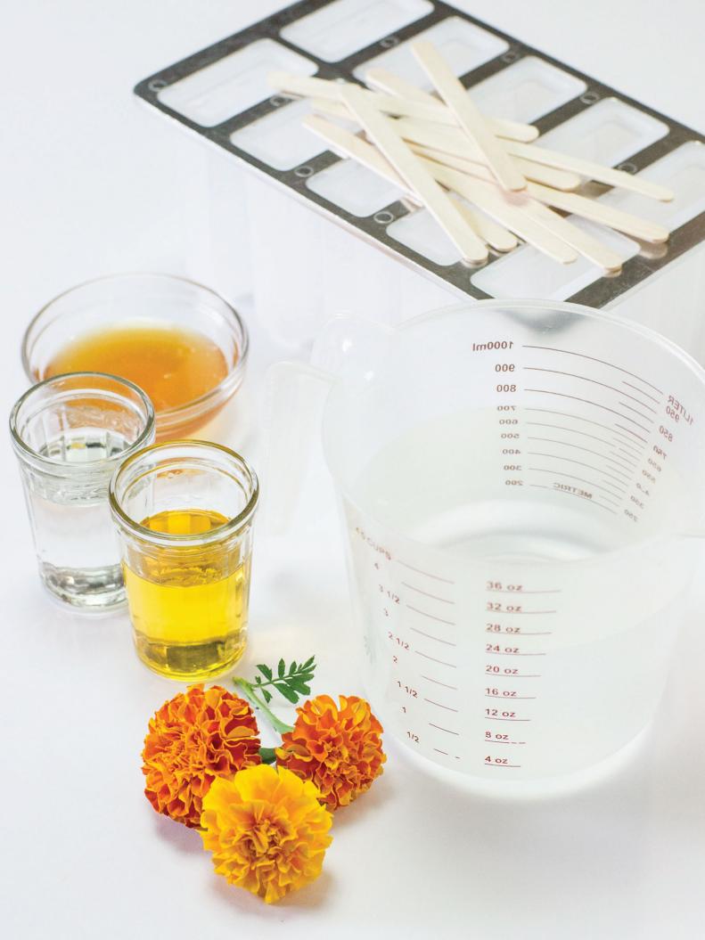 You will need: 3 cups warm water / 1/4 cup triple sec / 1/4 cup Licor43 / 3 tablespoons honey (or agave syrup), 1/2 teaspoon citric acid / pinch of salt / 8-10 medium marigold blossoms / popsicle mold and sticks