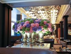 This quartet of silver-plated vases is stuffed with colorful puffs of hydrangea, <a target="_blank" href="http://www.mcqueens.co.uk/">McQueens'</a> favorite flower with which to liven up The Rosewood Hotel's main dining room.