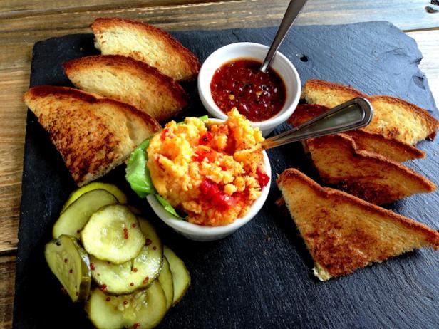 The quintessential Southern snack tray: pimento cheese, roasted red pepper jelly, buttered toasts and homemade pickles for a little crunch on top.