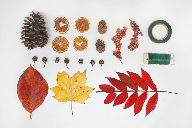 To create your fall garland you will need floral tape, floral wire, scissors, wire cutters, a stick to support your centerpiece and lots of colorful leaves. Look for small leaves still attached to their branch, and large single leaves. You may also want some fall items like pine cones, dried berries or dried orange slices.