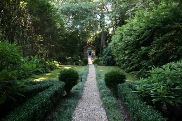 A pea gravel path leads from the parterre garden (with Harland dwarf boxwoods and Edgeworthia) to the potting shed. Along the way, there is confederate jasmine, <i>Ligustrum</i> (or Japanese privet), leucothoe shrubs, variegated Solomon’s seal and <i>osmanthus fragrans</i>, also known as tea olive. “I didn’t want the garden to look the same everywhere,” gardener Rosie Davidson says.