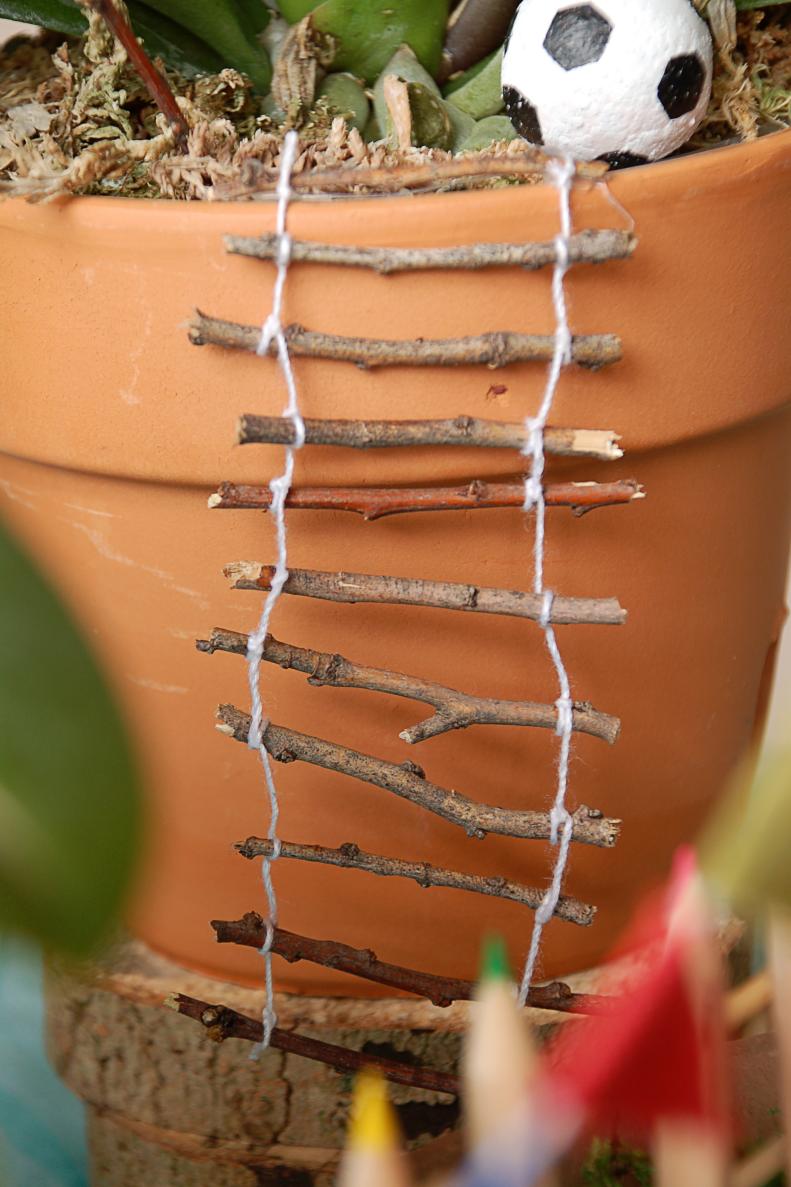Glue your finished ladder to the top edge of the pot and let it hang down. If you'd like a more traditional ladder, simply glue your rungs to two larger twigs rather than tying them with string.