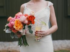 Jill holds her wedding bouquet and a Moscow Mule, which was her signature cocktail served at the reception. The floral arrangements at the wedding included a mix of peonies, garden roses, spray roses, dusty miller, ranunculus, sweet peas, dahlias, freesia, thistle and berries.