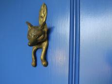A fox figurine adds detail to a brightly colored front door.&nbsp;