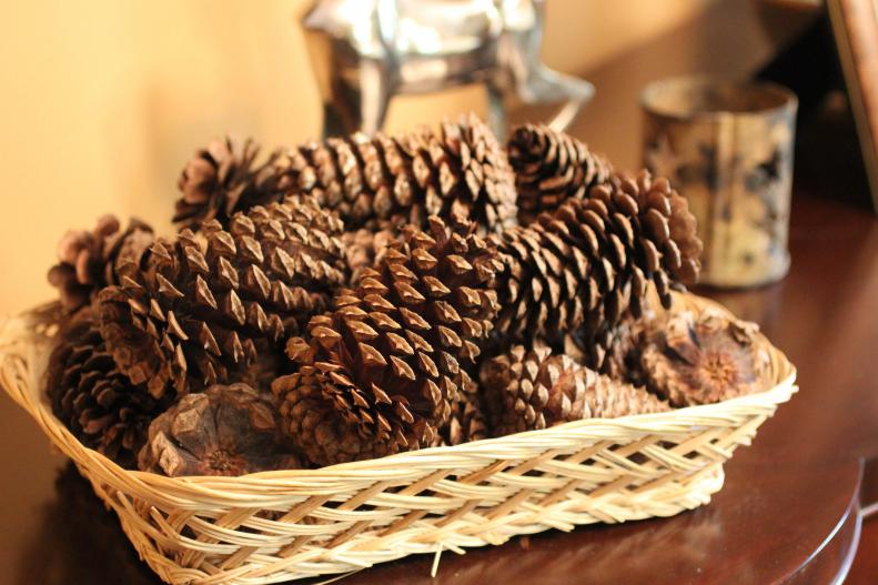 Pine cones are an inexpensive way to decorate seasonally. Arranged in a basket or vase by the front door, they invoke the holidays without putting out the hardcore Christmas decorations before a flake of snow has been forecast. Up the warm and cozy factor this year with DIY cinnamon-scented pine cones.