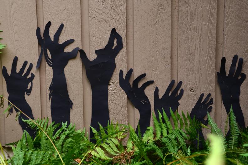 Add a spooky twist to the garden with a few zombie or mummy hands reaching up from the ground! Look for sheets of thin, black plastic to cut your hands out of. You can either hang them on the wall of your house, or attach them to stakes and plant them in the middle of your flower beds. If you're not sure how to draw hands, just grab a bright light and partner and trace the shadows of their hands so you know exactly where to cut.