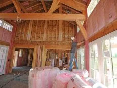 INTERIOR - Great Room - Rod Garcia installs insulation.