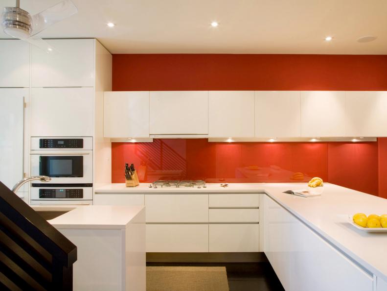 Modern Kitchen With Sleek White Cabinets and Red Backsplash