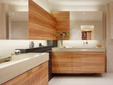 Concrete counter-tops and wood panel cabinets in a bathroom. 