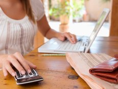 Woman with calculator and laptop