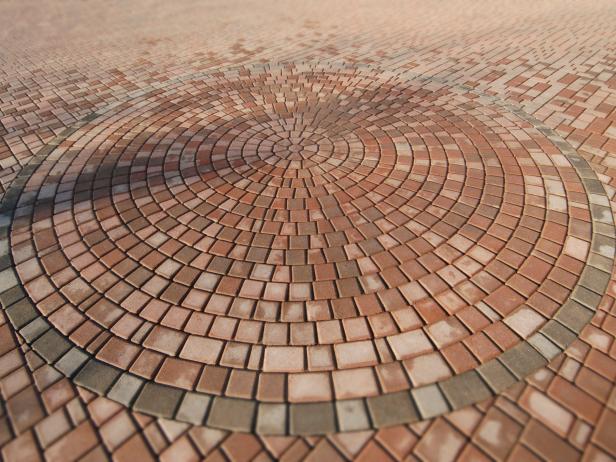 This outdoor space has a unique brick paver circle in its landscape design. 