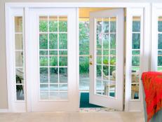 Open white French doors without curtains leading to the backyard area. 