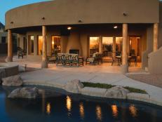Exterior of house with outdoor patio lighting and the reflection bouncing off the pool water. 