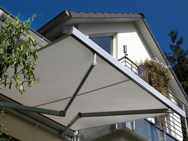 White house exterior with fold out awning to shade the deck area. 