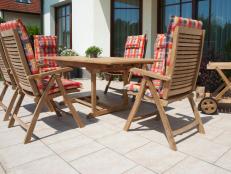 Outdoor seating area with padded chairs and neutral toned deck tile. 