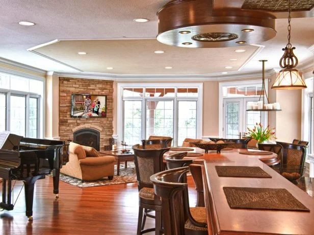 Natural materials and earthy hues create an inviting feel in this open living dining area, which features a plasma TV mounted neatly over the fireplace.