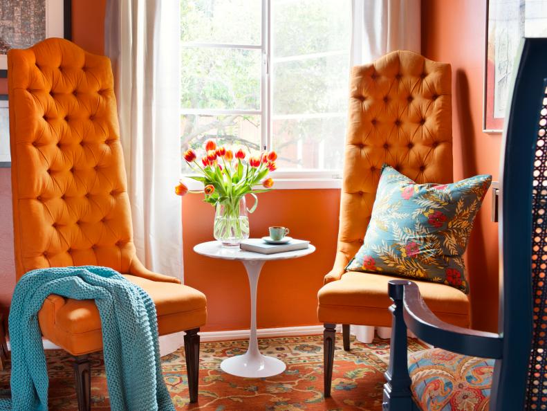 Two Orange Chairs Next to a Casement Window