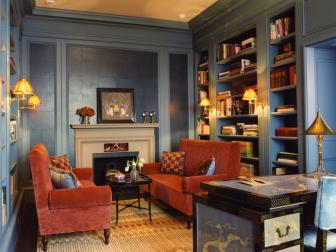 Blue Home Office With Built-In Shelving and Red Sofas