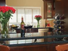 Blue kitchen countertop winebar area with wine rack and red floral decor. 