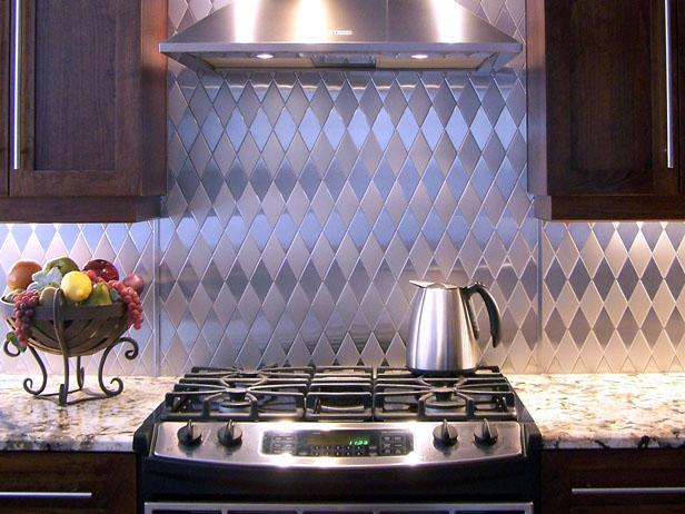 Hood and range with a stainless steel backsplash in this kitchen design.