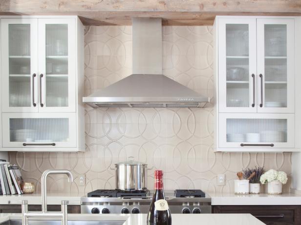 Transitional design with modern and rustic detail in this kitchen. This kitchen features a large-scale pattern fascade backsplash that visually pushes the walls up and out.