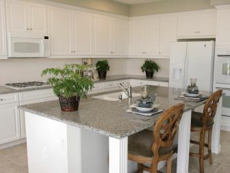 White kitchen with large kitchen island and neutral countertops. 