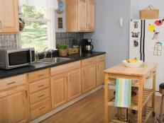 A angle shot of oak wood kitchen cabinets in a small kitchen.