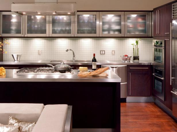 A small kitchen with glass door upper cabinets and a large kitchen island.