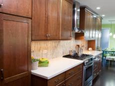 Kitchen With Brown Wood Cabinets, White Counters and Stainless Range