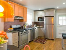 Kitchen With Orange & Gray Cabinets and Stainless Steel Appliances