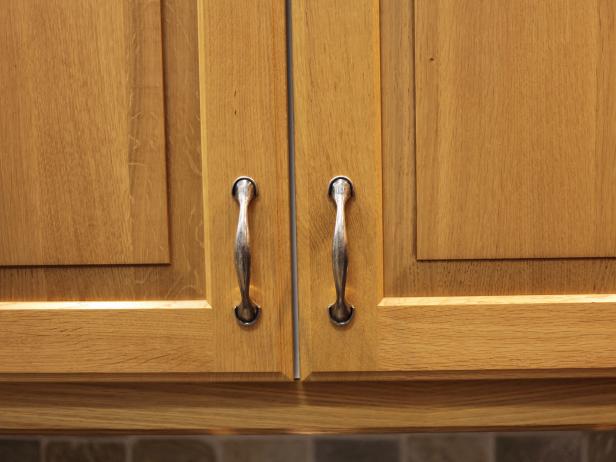 A detail shot of handles on oak kitchen cabinets.