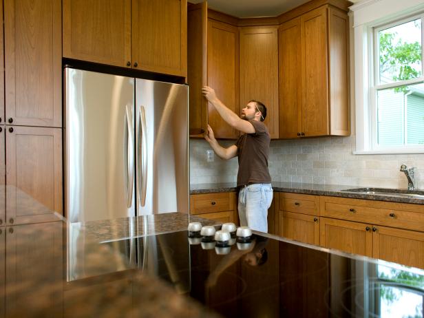 A contractor working on and installing kitchen cabinets in new home.