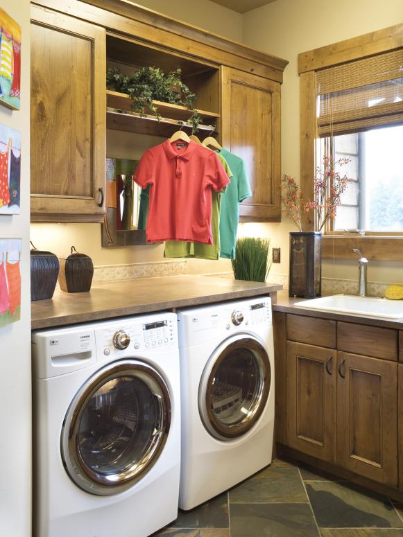 Rustic Laundry Room With Light Wood Cabinets and White Washer & Dryer