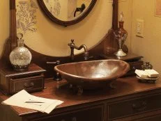 This vanity is complete with copper colored fixtures and hammered copper sink. The textured walls offer a number of artistic renditions.