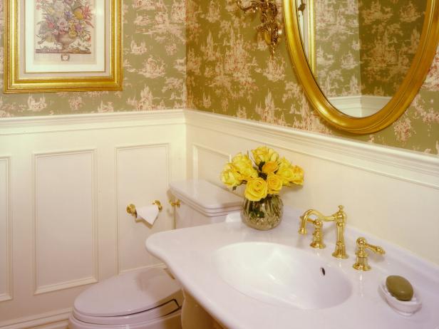 Wood paneling and a chair rail add formality to this charming powder room tucked under the central stairs of a new colonial-style home.