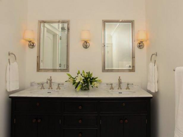 Crisp white walls and marble floors provide the backdrop to this traditional vanity, making the look fresh and clean. Recessed medicine cabinets are flanked by sconces with linen shades.