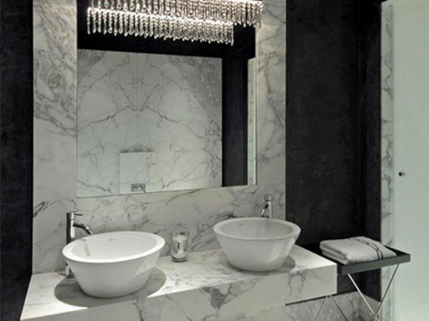 This contemporary bathroom design by Michael Habachy features black Venitian plaster walls and white marble that surrounds the mirror and extends into the vanity and floors.