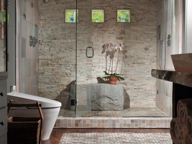 Luxury means being able to do yoga poses in your shower â   at least for one of designer Susan Fredman's clients. She delivered not only a large space but also a dramatic boulder rock for seating. Earth tones, textured tiles, natural light and a steam shower complete this soothing, masculine space.