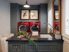 MacKenzie Brothers customâ  crafted birch plywood cabinetry faced with earth-friendly MDF paneling for the laundry and mud room. An eco-friendly CaesarStone countertop in a smoky ash shade and industrial-style bronze pendant lights complete the look.