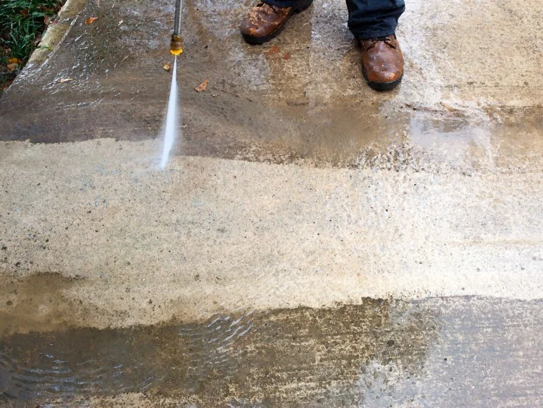 Change tip labeled â  soapâ   to tip labeled â  25 degreeâ  . Pressure wash concrete by holding down spray handle, working your way back and forth from one side of concrete surface to the other, overlapping each stroke by 6 to 8 inches. TIP: For tougher stains such as paint, hold tip 3 to 4 inches from concrete surface, moving with slower, nearly still strokes to ensure removal.