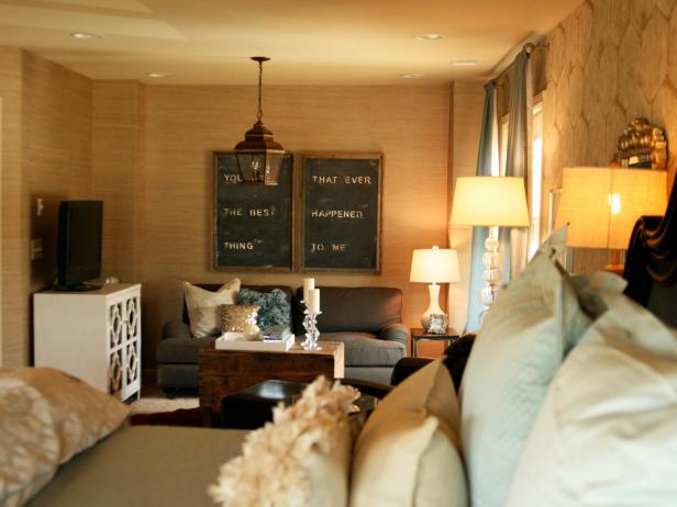 A variety of lighting warms up this bedroom. A hanging lantern adds a vintage feel to the seating area, while can lights illuminate the space. Photography by Julie Holloway