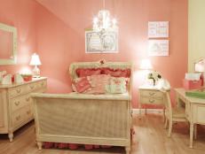 The custom bedding and wall art are color coordinated and complement the sweet, girly coral-colored walls.