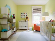 If you want to incorporate bold colors in a nursery, design a room with soft neutrals first. The soothing green walls and light-blue carpet tiles provide the perfect foundation for this nursery. The orange rocker pops in the corner, and colorful accessories and toys are bold yet functional accents.