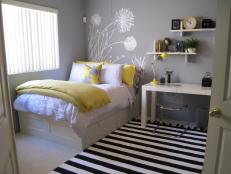 Yellow, gray, white, and black bedroom design with dandelion mural, yellow and white bedding, desk area with floating shelves, black and white  striped rug.