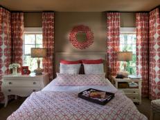 The hot coral hue of drapery fabric informed the room's color palette, with a collection of bold prints popping against neutral walls and carpeting.