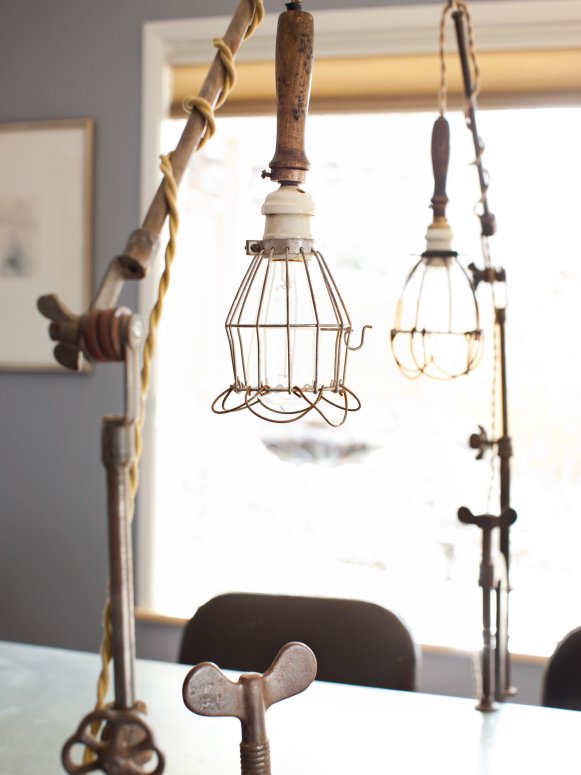 To keep themwork surface illuminated properly, rustic, caged, turn-of-the-century construction lights are clamped directly to the top of the table.