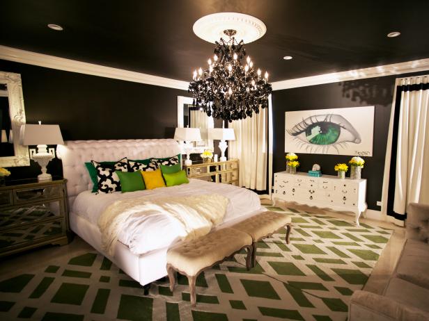 A large ornate chandelier makes a dramatic statement in this black and white bedroom. Mirrored dressers act as nightstands and add a little glamour to the space.