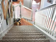 Previously covered in dated, cut-pile carpet, this stairwell was completely transformed by installing a custom runner made from patterned sisal with a 2-inch canvas border.