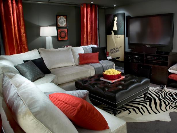 The white sectional, red accent and ample lighting keep the space from feeling dark and drab.